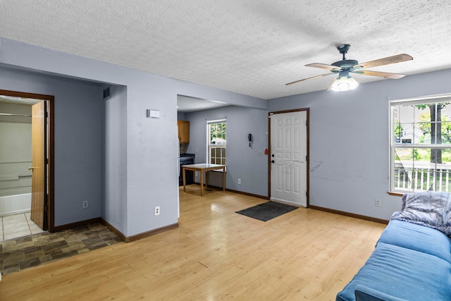353 Clarendon Ave, Columbus, OH 43223 - living room featuring ceiling fan, baseboards, light wood-type flooring, healthy amount of natural light, and a textured ceiling