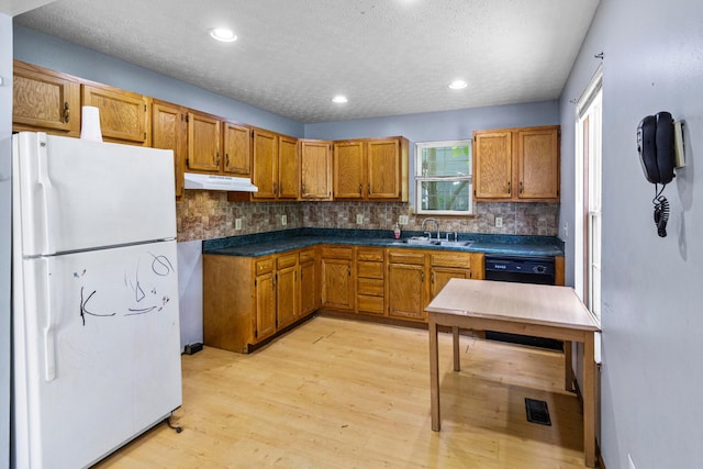 353 Clarendon Ave, Columbus, OH 43223 - kitchen featuring freestanding refrigerator, a sink, brown cabinets, under cabinet range hood, and tasteful backsplash