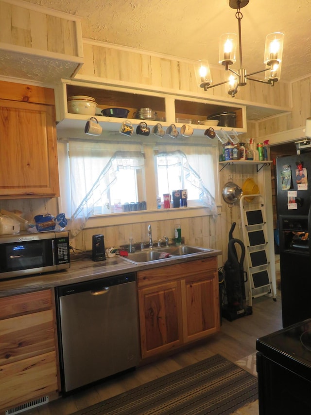kitchen featuring a sink, appliances with stainless steel finishes, brown cabinets, and visible vents