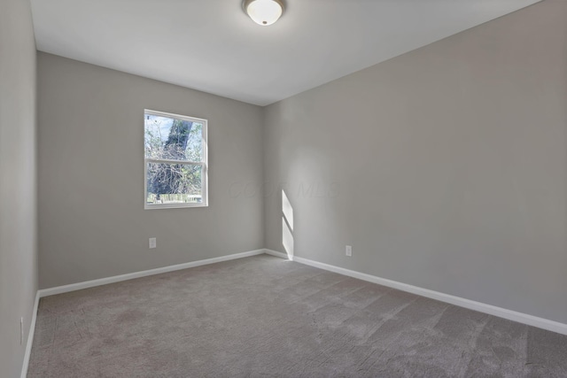 carpeted empty room with baseboards