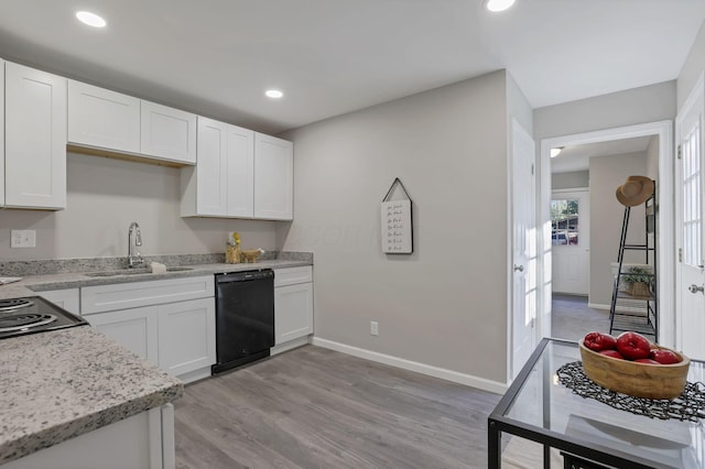 kitchen with baseboards, light wood-style floors, black dishwasher, white cabinetry, and a sink