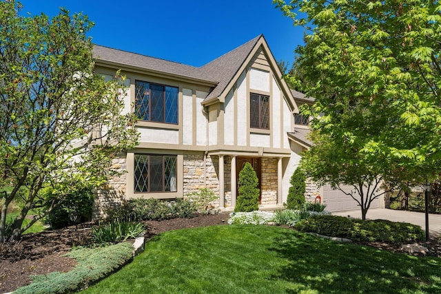 12385 Woodsfield Cir E, Pickerington, OH 43147 - tudor-style house featuring driveway, a front yard, a garage, stone siding, and stucco siding