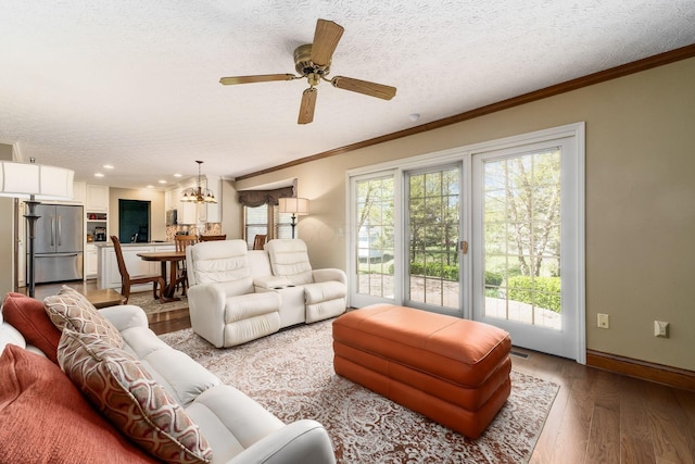 12385 Woodsfield Cir E, Pickerington, OH 43147 - living room with crown molding, a textured ceiling, light wood finished floors, and a healthy amount of sunlight