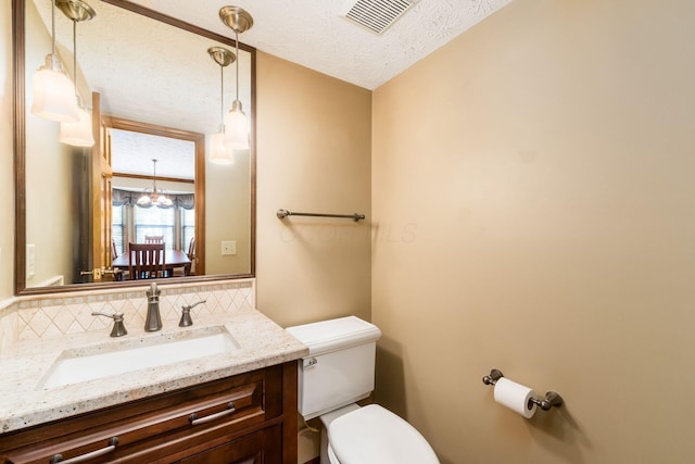 12385 Woodsfield Cir E, Pickerington, OH 43147 - bathroom with visible vents, vanity, toilet, a textured ceiling, and a notable chandelier