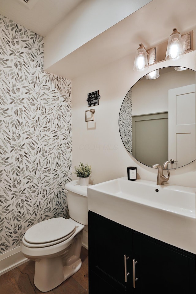1012 Ewing Aly, Columbus, OH 43201 - half bath featuring toilet, baseboards, wood finished floors, and vanity