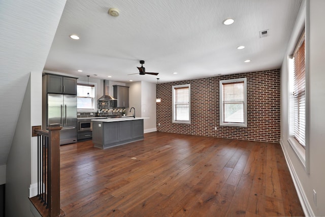 1012 Ewing Aly, Columbus, OH 43201 - unfurnished living room with dark wood-type flooring, a ceiling fan, a sink, and brick wall