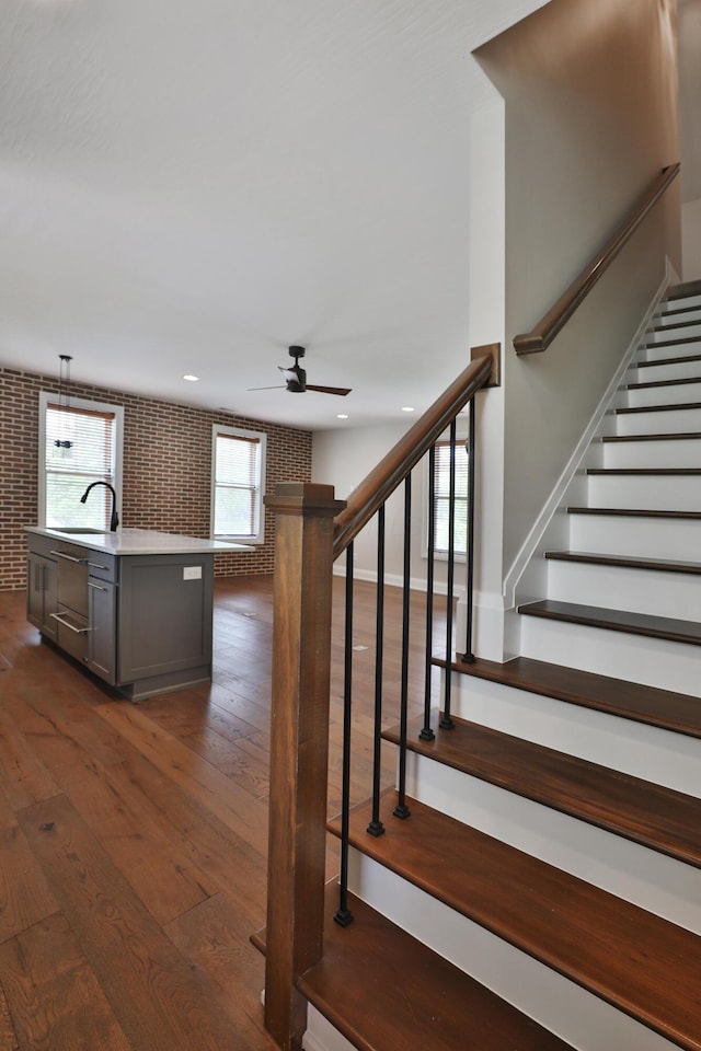 1012 Ewing Aly, Columbus, OH 43201 - stairway featuring recessed lighting, ceiling fan, brick wall, and hardwood / wood-style flooring