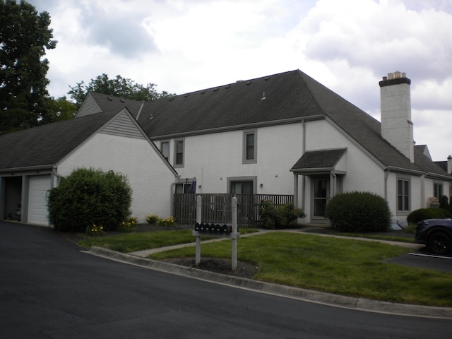 302 Saint Andrews Dr Unit 302, Dublin, OH 43017 - view of front facade featuring a chimney, a garage, a front yard, and a shingled roof