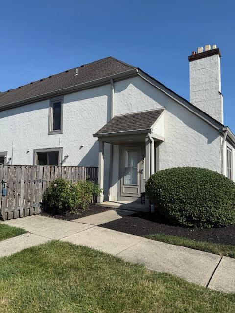 302 Saint Andrews Dr Unit 302, Dublin, OH 43017 - view of home's exterior with stucco siding and a chimney