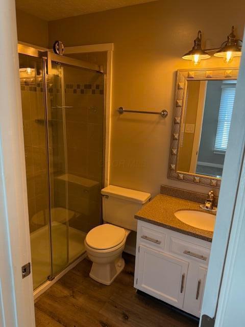 302 Saint Andrews Dr Unit 302, Dublin, OH 43017 - bathroom with a shower stall, vanity, and wood finished floors