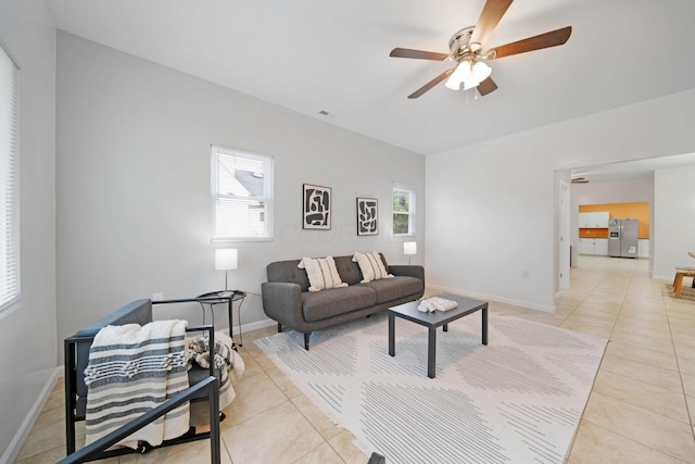 living room featuring light tile patterned flooring, a ceiling fan, and baseboards