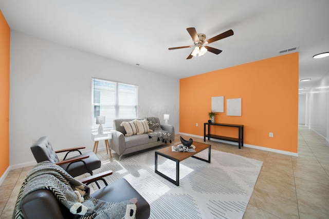 living room with a ceiling fan, baseboards, and light tile patterned flooring