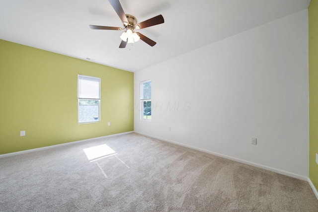 unfurnished room featuring carpet flooring, baseboards, and ceiling fan