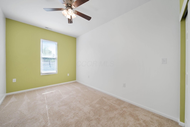 carpeted empty room with a ceiling fan and baseboards