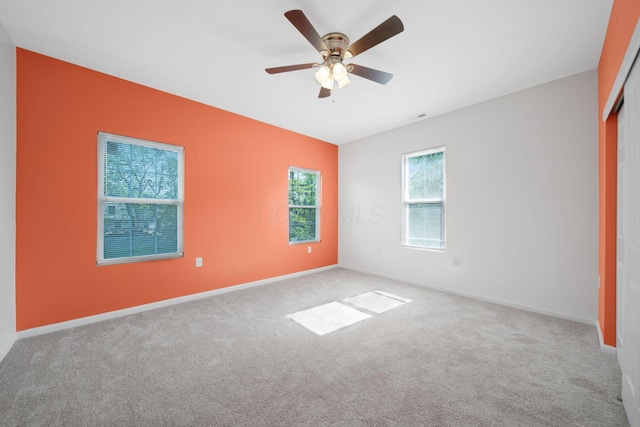 spare room featuring carpet flooring, ceiling fan, and baseboards