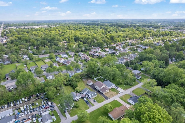 view of property location featuring a forest and nearby suburban area