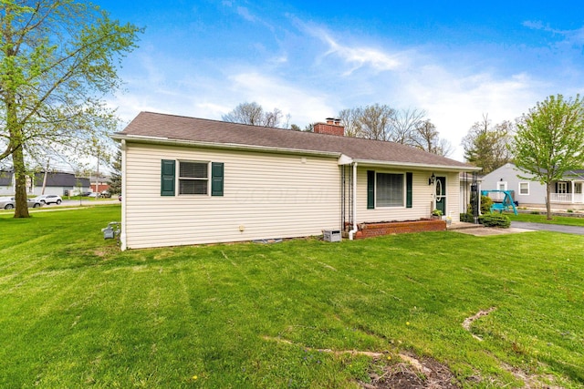 view of front of home with a chimney and a front yard