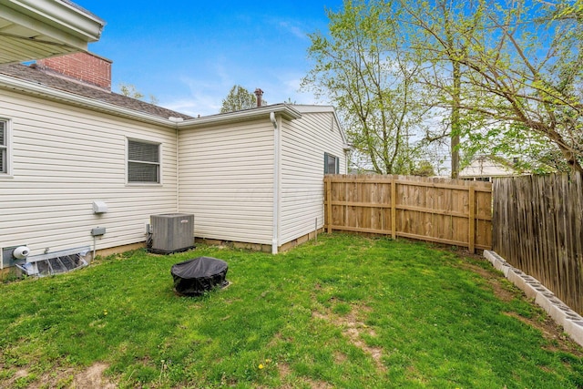 view of yard with a fenced backyard and central AC unit