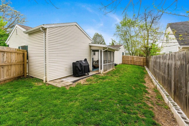 exterior space with a fenced backyard and a sunroom