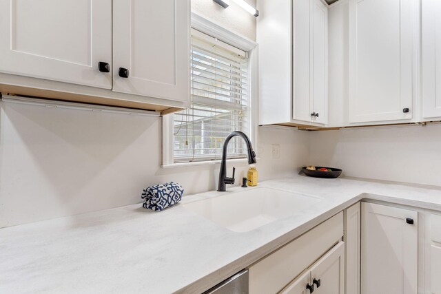 kitchen with a sink, white cabinetry, and light countertops