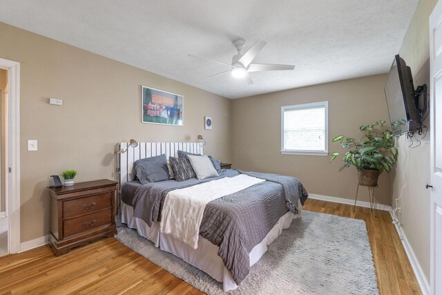 bedroom with light wood-style floors, baseboards, and ceiling fan