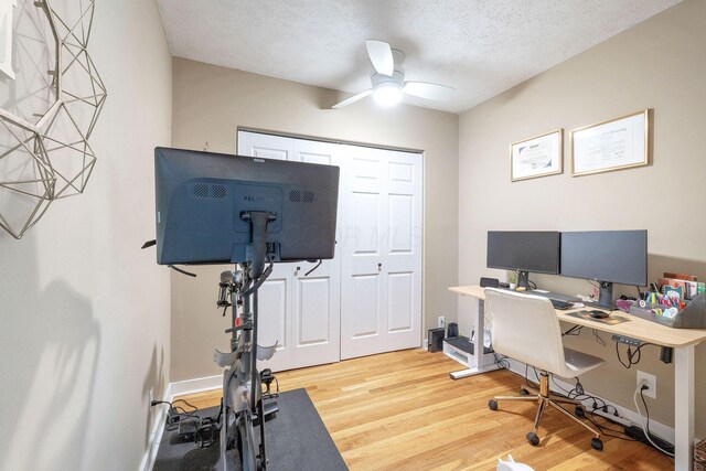 home office with a ceiling fan, a textured ceiling, and light wood finished floors