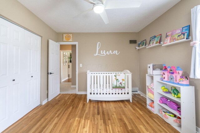 bedroom with visible vents, a closet, baseboards, light wood-type flooring, and a ceiling fan
