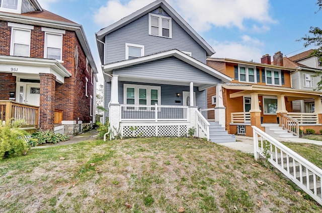 view of front of house featuring covered porch, a front lawn, and brick siding
