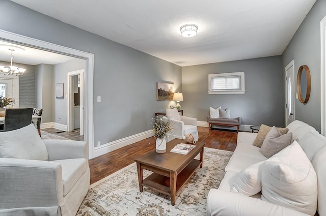 living room featuring baseboards, wood finished floors, a notable chandelier, and baseboard heating