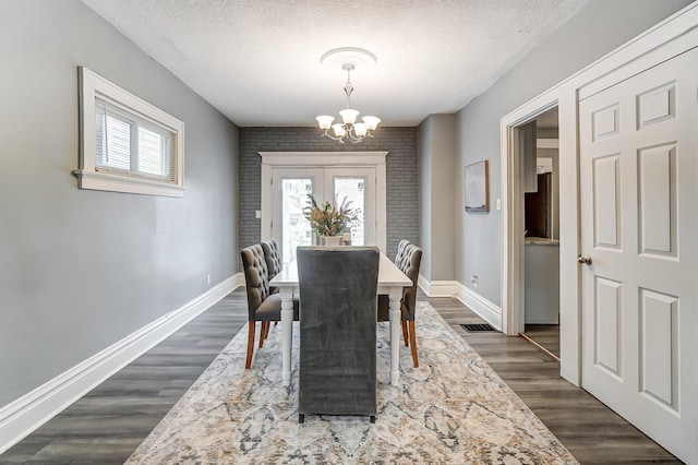 dining area with a textured ceiling, baseboards, an inviting chandelier, and a wealth of natural light