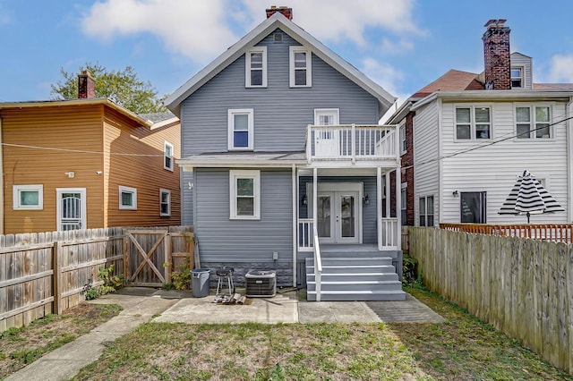 rear view of property featuring a fenced backyard, central AC, french doors, and a gate