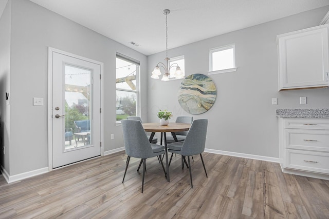 dining room with baseboards, a notable chandelier, visible vents, and light wood-style floors