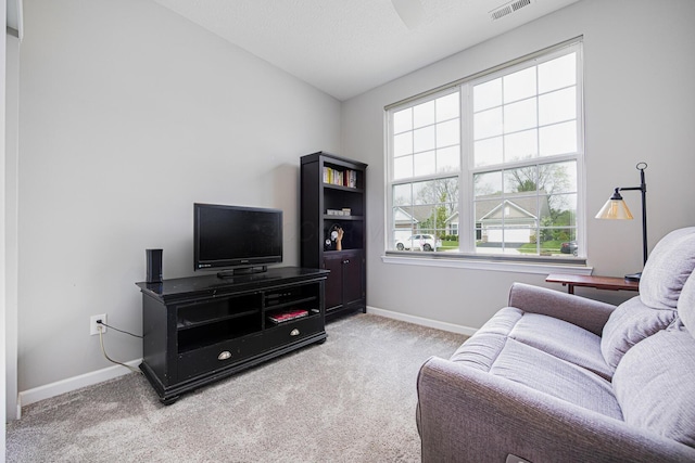 carpeted living room featuring baseboards, visible vents, and lofted ceiling