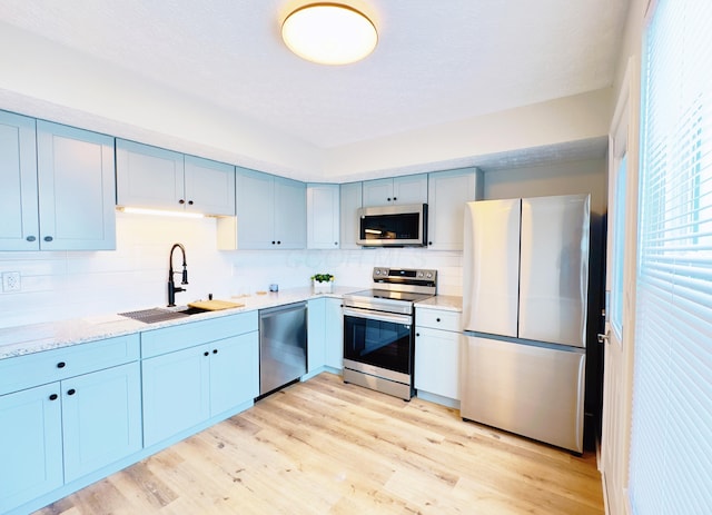 2462 Sanford Dr, Columbus, OH 43235 - kitchen featuring a sink, decorative backsplash, stainless steel appliances, and light wood finished floors
