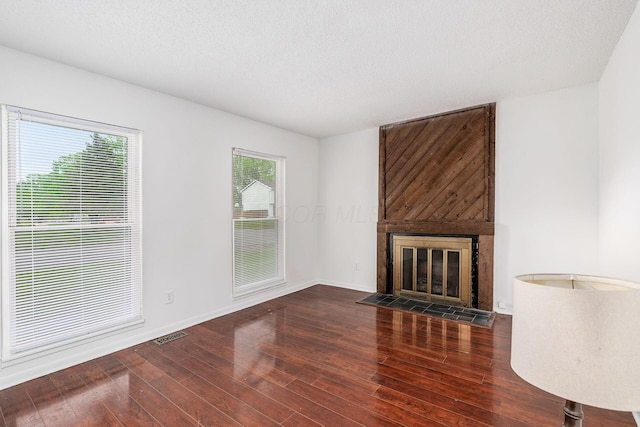 6556 Centennial Dr, Reynoldsburg, OH 43068 - unfurnished living room with a textured ceiling, baseboards, visible vents, wood finished floors, and a fireplace