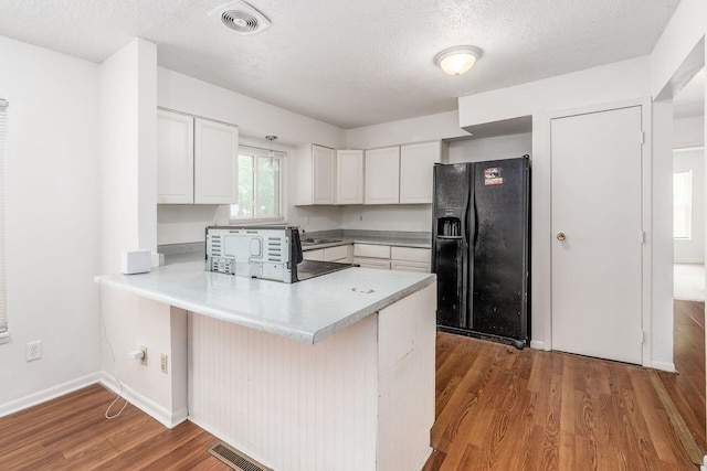 6556 Centennial Dr, Reynoldsburg, OH 43068 - kitchen featuring a peninsula, wood finished floors, black fridge, white cabinetry, and light countertops