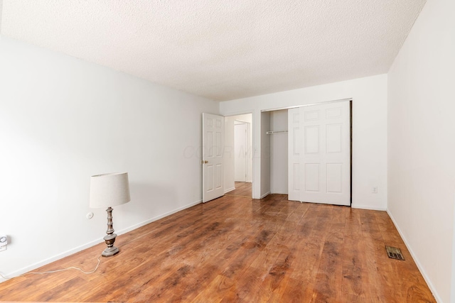 6556 Centennial Dr, Reynoldsburg, OH 43068 - unfurnished bedroom with a closet, a textured ceiling, visible vents, and wood finished floors