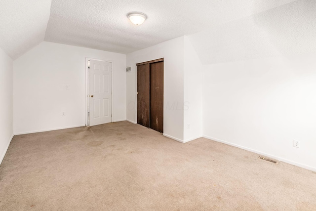6556 Centennial Dr, Reynoldsburg, OH 43068 - additional living space with lofted ceiling, a textured ceiling, visible vents, and light colored carpet