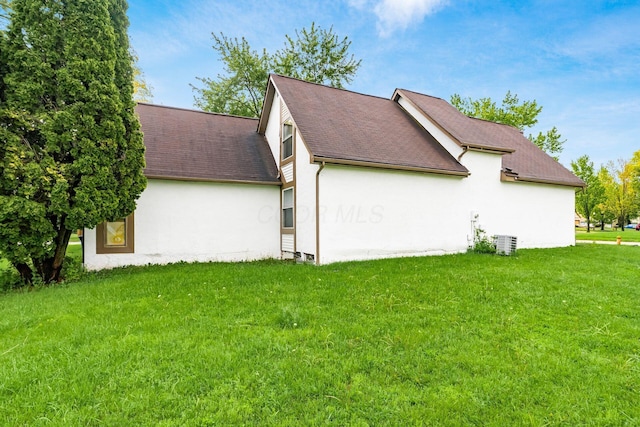 6556 Centennial Dr, Reynoldsburg, OH 43068 - view of side of home with a lawn, stucco siding, and a shingled roof