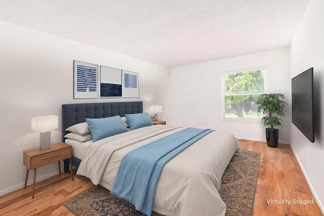 6556 Centennial Dr, Reynoldsburg, OH 43068 - bedroom with a textured ceiling, baseboards, and light wood-style floors