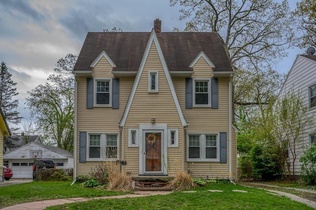 2513 Georgetown Ave, Toledo, OH 43613 - view of front of house with a detached garage, roof with shingles, a chimney, and a front yard