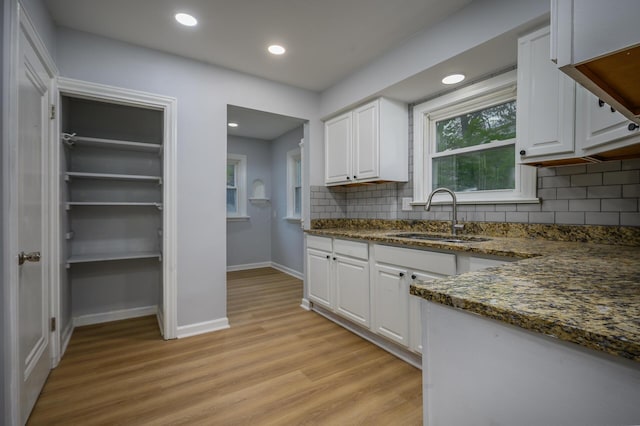 2513 Georgetown Ave, Toledo, OH 43613 - kitchen featuring light wood-style floors, a sink, white cabinetry, and decorative backsplash