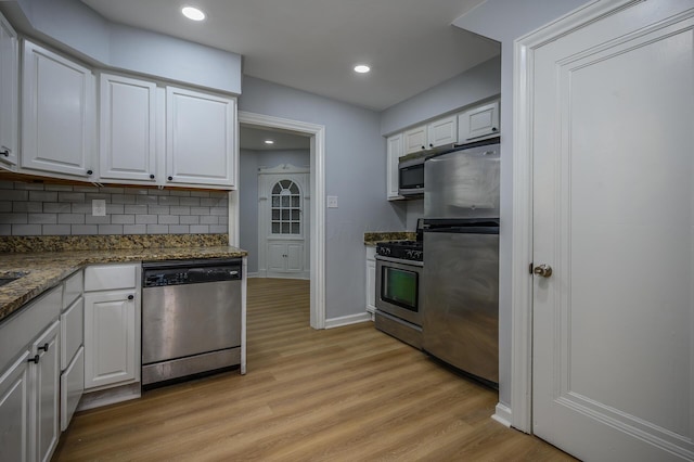 2513 Georgetown Ave, Toledo, OH 43613 - kitchen featuring white cabinets, appliances with stainless steel finishes, decorative backsplash, and light wood finished floors
