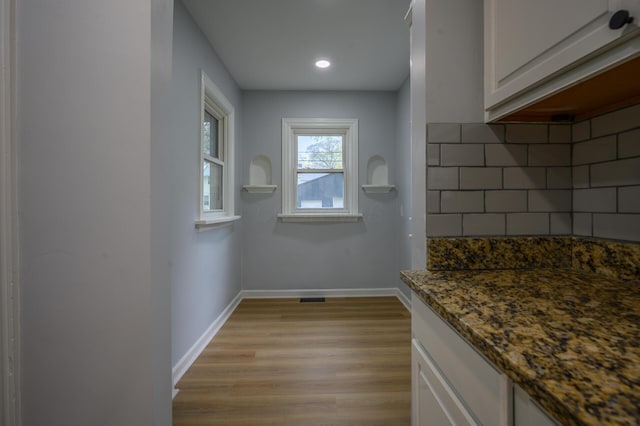 2513 Georgetown Ave, Toledo, OH 43613 - interior space featuring white cabinets, decorative backsplash, dark stone counters, and light wood finished floors