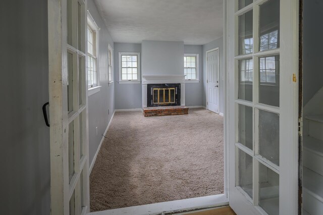 2513 Georgetown Ave, Toledo, OH 43613 - unfurnished living room featuring a brick fireplace, baseboards, and carpet