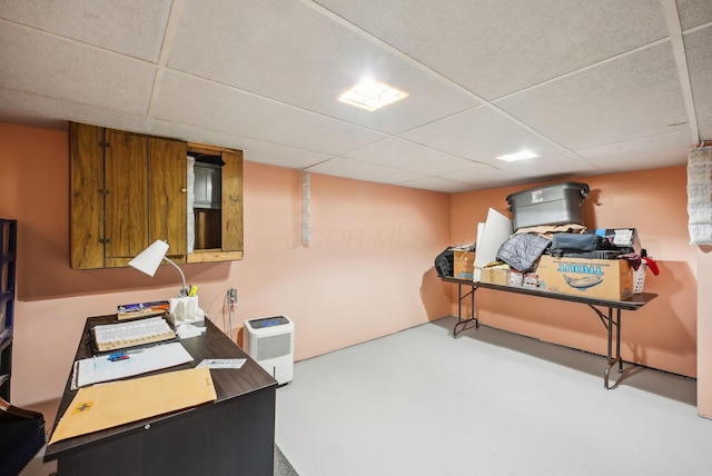 office area featuring concrete flooring and a paneled ceiling