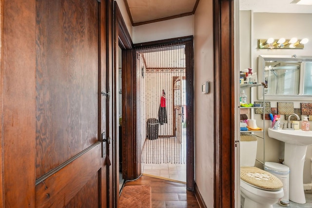 bathroom with visible vents, wood finished floors, toilet, baseboards, and a sink