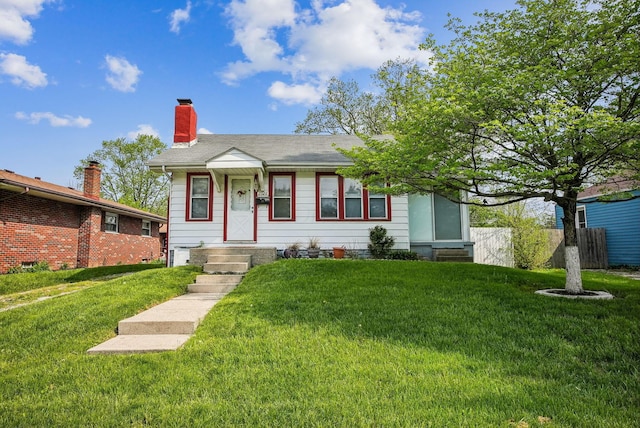 view of front of house featuring fence, a chimney, and a front yard