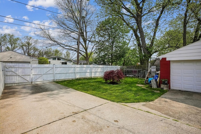 view of yard featuring a gate, fence, and driveway