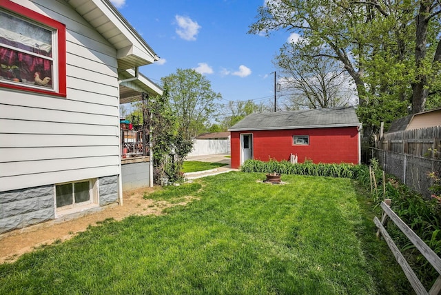 view of yard with fence and an outbuilding